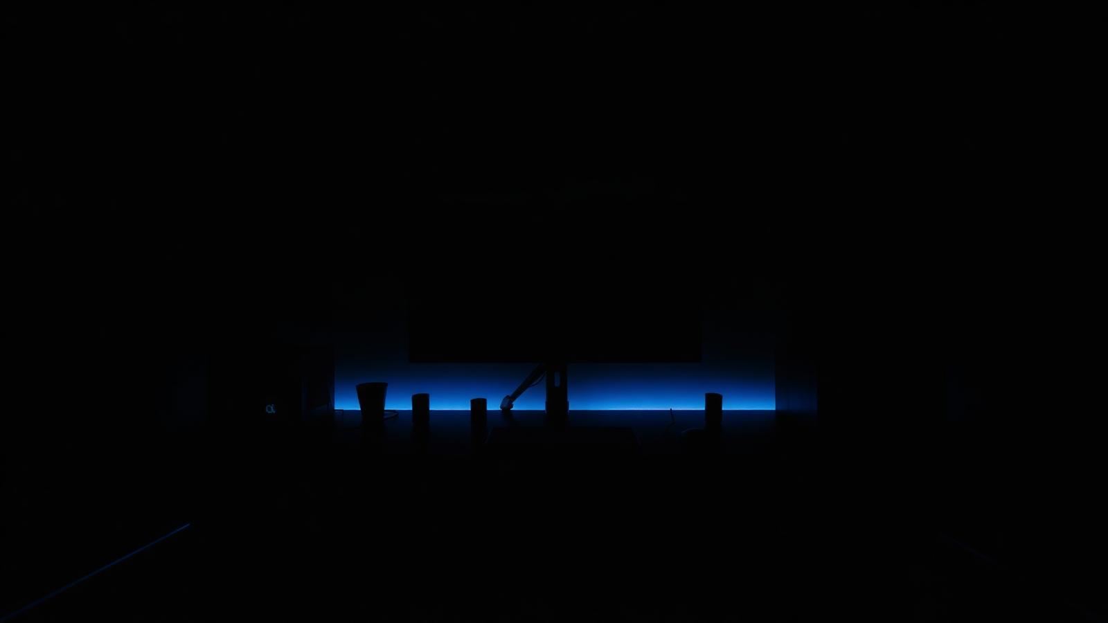 Dark gaming desk with subtle blue ambient lighting